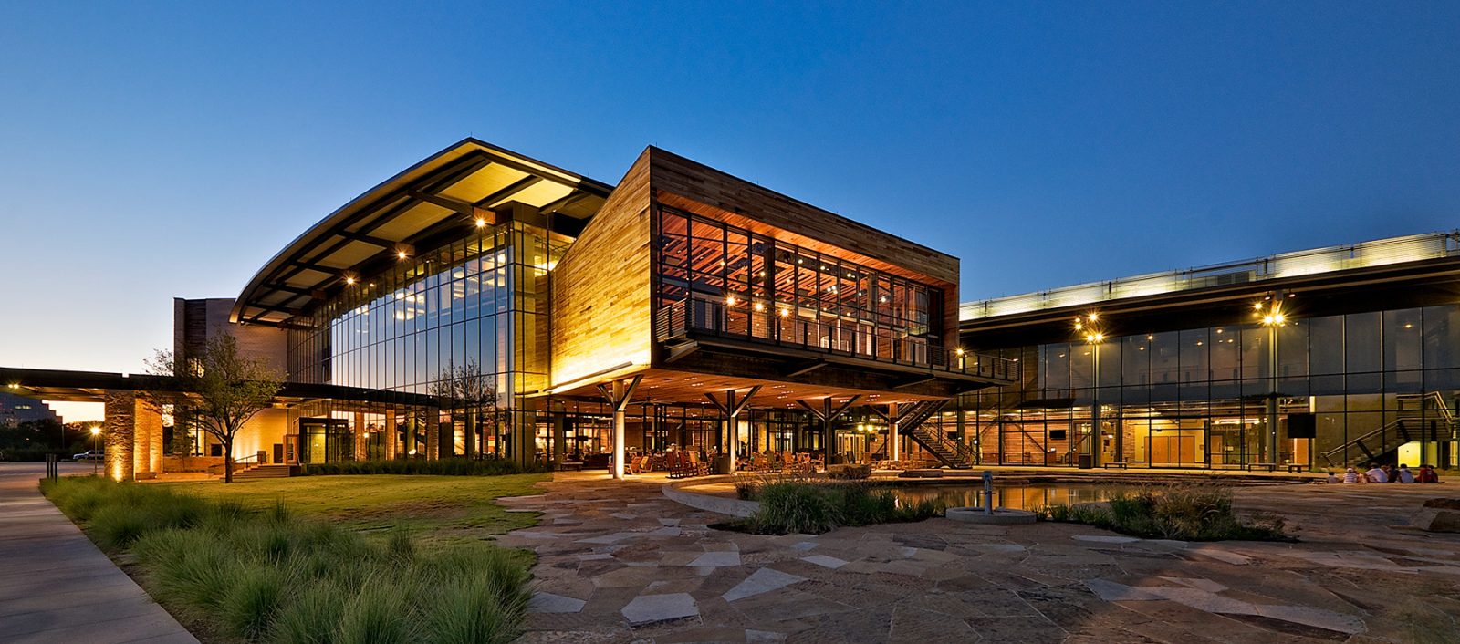 Evening view of Watermark Community Church, highlighting its modern architectural design and illuminated glass facade.