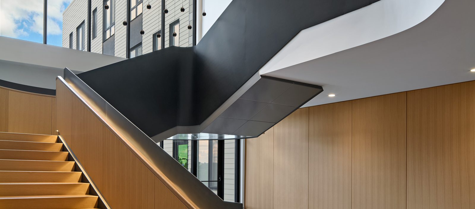 Interior view of the Baldwin showcasing a wooden staircase and natural light spilling in for the window facade.