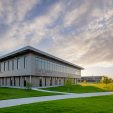 Exterior view of the Forney ISD Jackson Middle School and Rhodes Intermediate School Joint Campus featuring modern architecture and lush green grass.