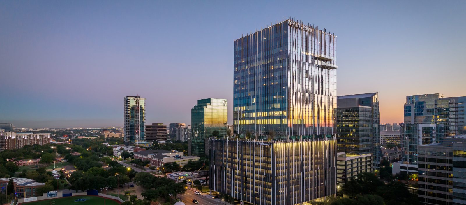 Harwood No. 14, a modern high-rise office building designed by our structural engineering team, located in a vibrant urban area at dusk