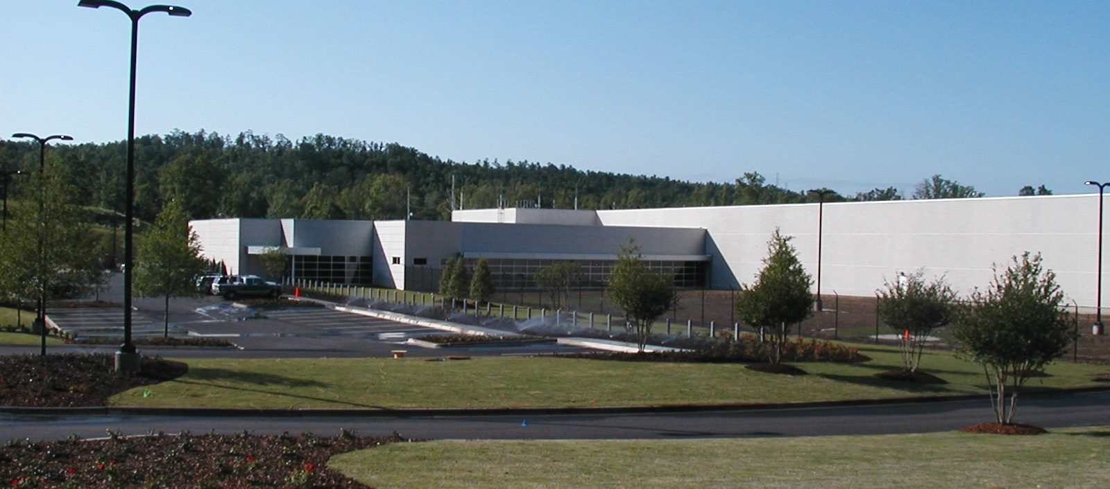 Oxmoor Data Center exterior, a wide shot showing the building with a white and silver materials, designed by our structural engineering team, surrounded by grass and trees